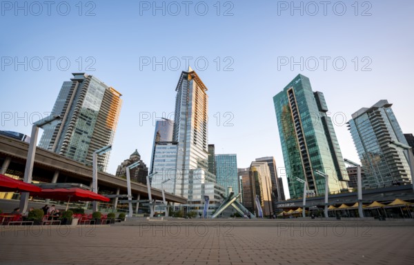 Olympic Cauldron Statue, Jack Poole Plaza Square, skyscrapers on the promenade at sunset, Coal Harbour, Vancouver, British Columbia, Canada
