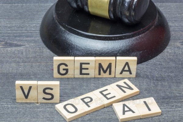 Letter cubes in front of a judge's hammer show the words GEMA VS OPEN AI