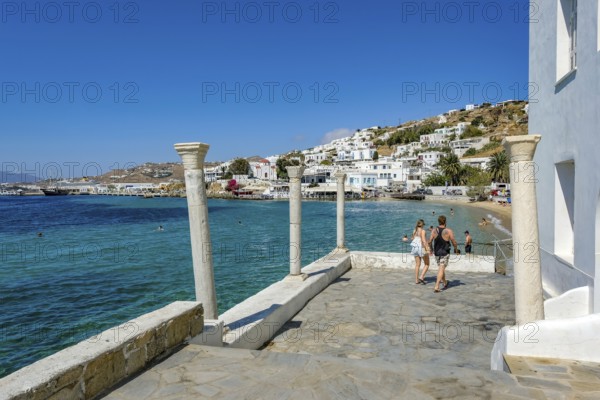 Mykonos, Cyclades, Greece - Tourists and locals like to bathe at the small town beach Paralia Cheras Mikonou right at the old port in the old town of Mykonos Town, Mykonos Chora. Mykonos is part of the Cyclades archipelago