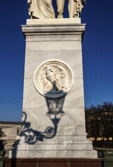 The shadow of a street lamp on the pedestals of the group of figures on the Schlossbrücke, Unter den Linden, Berlin, Germany