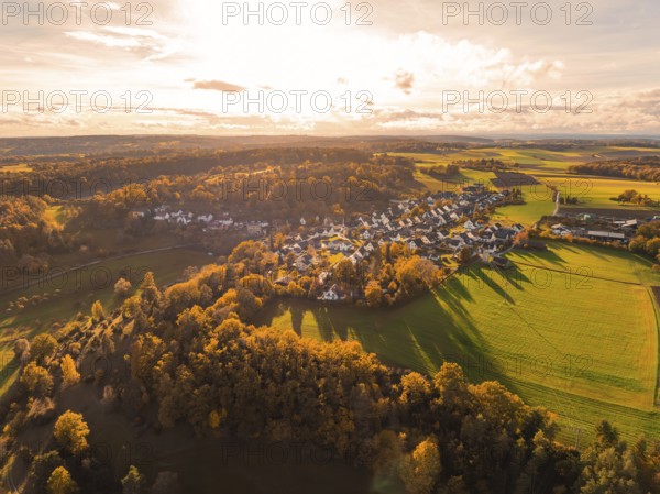 Panoramic autumn view of a village surrounded by golden fields and wooded hills in sunlight, Lehenweiler, Aidlingen, Böblingen district, Germany