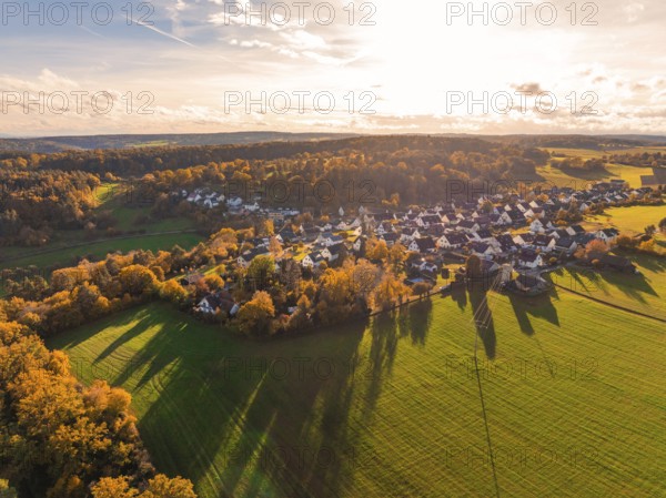 Village in autumn colors with long shadows, surrounded by fields and forests in golden sunlight, Lehenweiler, Aidlingen, Böblingen district, Germany