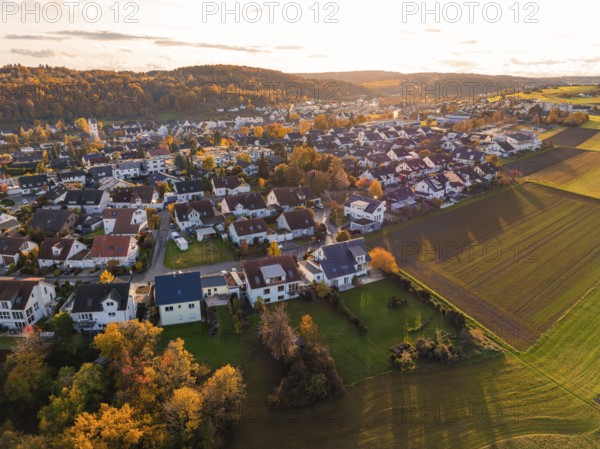 Settlement and fields in evening light, autumn hills with colorful trees, Aidlingen, Böblingen district, Germany