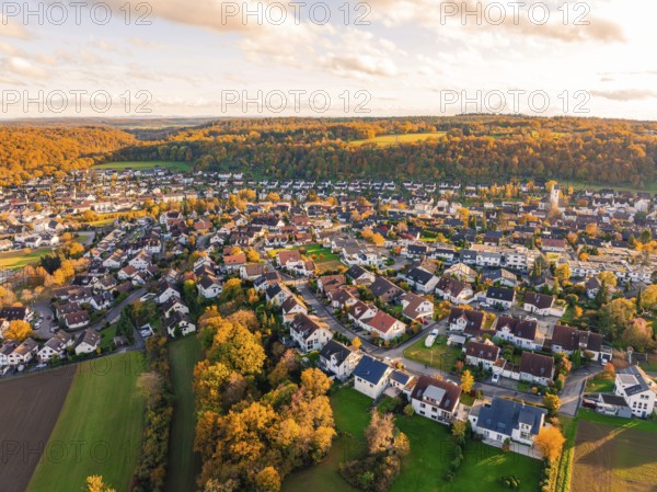 Pretty village surrounded by colorful autumn trees at sunset, Aidlingen, Böblingen district, Germany