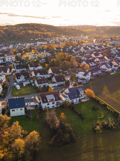 Near settlement with autumn trees and roofs, illuminated by golden sunlight, Aidlingen, Böblingen district, Germany