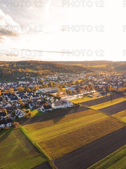 Aerial view of a village surrounded by fields in warm autumn colors, Aidlingen, Böblingen district, Germany