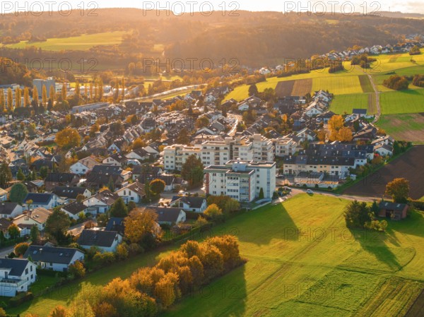 Settlement in autumn landscape with golden light over green fields and hills, Aidlingen, Böblingen district, Germany
