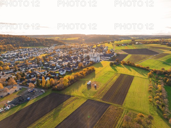 Diverse fields and settlement under autumn evening light in hilly area, Aidlingen, Böblingen district, Germany