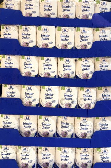 Many large quantities of stacked sugar packets on sale by retailers at retailers, Germany