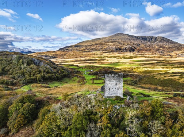 Autumn colours over Castell Dolwyddelan and Eryri Mountains from a drone, Snowdonia, Conwy County Borough, Wales, England, United Kingdom