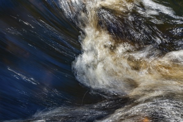 Stream flow with dark water, reflections and turbulences, long exposure, Sweden