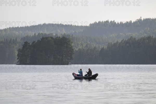 Paddler, lake surrounded by forest, near Sunne, Sweden