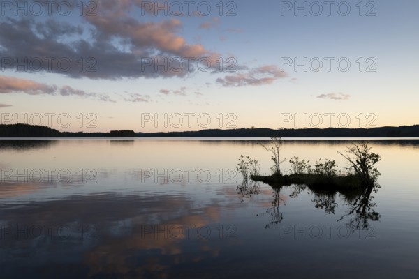 Clouds reflected on the water surface, silhouette of a small island, forest lake, evening mood, at Sunne, Sweden