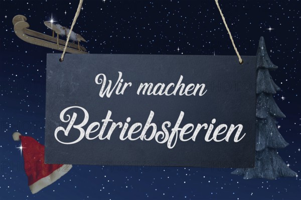 (Photo montage) Company holidays at Christmas: sign with the inscription WIR MACHEN BETRIEBSFERIEN in front of a starry sky