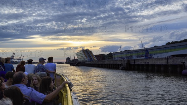 Harbour ferry line 62 with passengers on the Elbe, harbour cruise at sunset, Docklands, Hamburg, Germany