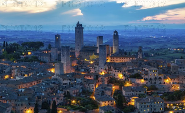 City view of San Gimignano at dusk, gender towers and medieval buildings, Tuscany, Italy