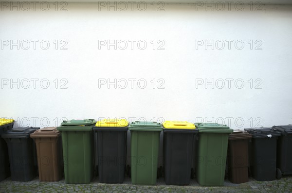 Garbage bins stand in front of house wall, green waste bin, brown bin for organic waste, black bin for residual waste, Bietigheim-Bissingen, Baden-Württemberg, Germany
