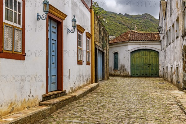 Alley with old colonial-style houses and sunlit cobblestones in the historic city of Ouro Preto in Minas Gerais, Brasil