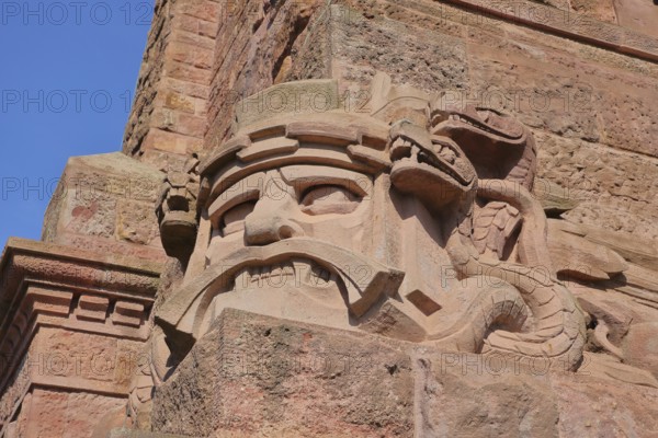 Warrior's face with snake figure and dragon at the Kyffhäuser monument, detail, figure, stone, red, face, Kyffhäuser monument, Kyffhäuser, Thuringia, Germany