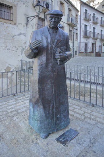 Sculpture and monument to priest Don Ramon Nunez Martin, statue man with book, life-size, bronze sculpture, modern art, Trujillo, Extremadura, Spain
