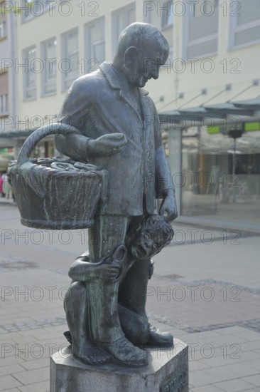 Pretzel Adam sculpture by Werner Bernd 1977, modern art, life-size man standing with basket and child, pretzel, selling, giving, caring, handing out, giving, symbol, food, Kaiserslautern, Rhineland-Palatinate, Germany
