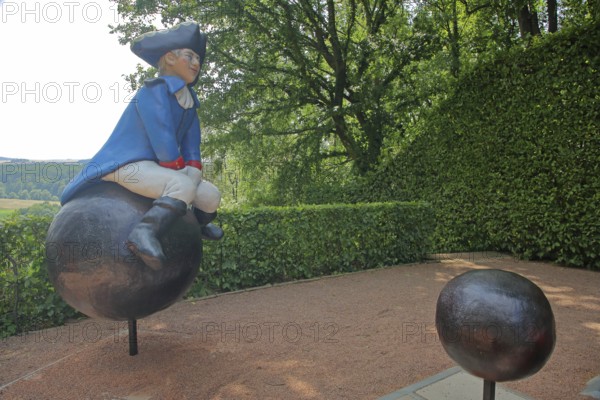 Baron von Münchhausen sculpture in the castle park, lying baron, uniform, blue, white, hat, cannonball, sitting, riding, bullets, castle, Lichtenwalde, Niederwiesa, Saxony, Germany