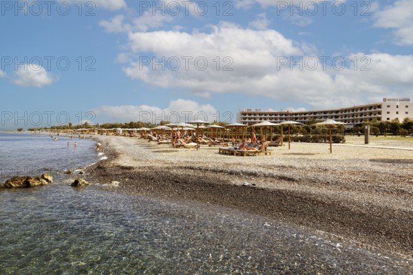 Parasol, sun lounger, sea, pebble beach, piled up with sand, people on the beach, Hotel Mitsis Ramira, Psalidi region, Kos island, Dodecanese Islands, Greece