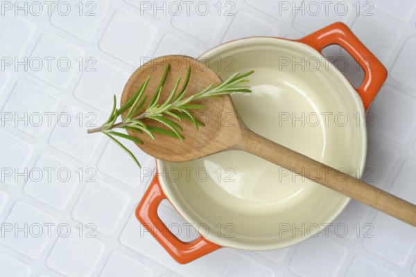 Rosemary, rosemary sprig on cooking spoon with cooking pot
