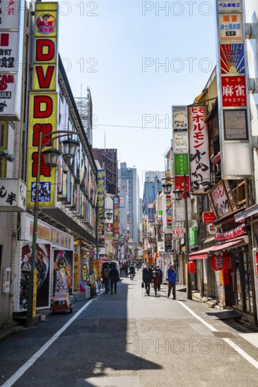 Street scene, lots of colorful signs of shops, restaurants and bars in a street, Shinjuku City, Tokyo, Japan