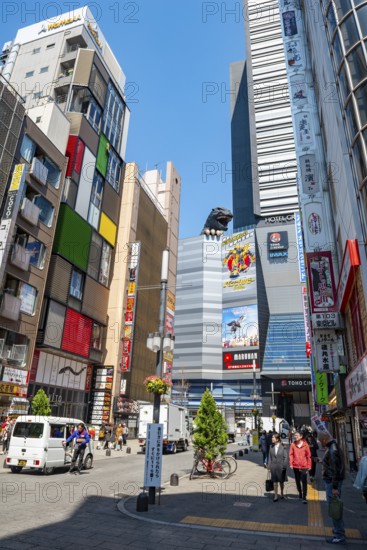 Street scene with skyscrapers, figure Godzilla head on a skyscraper, Shinjuku City, Tokyo, Japan