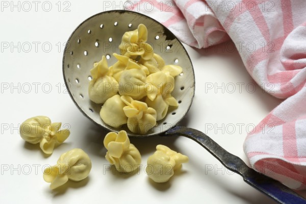 Saccottini, type of Italian pasta in a sieve ladle, pasta from Italy
