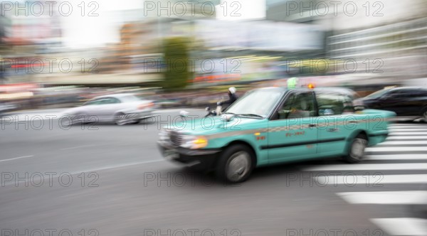 Elderly turquoise taxi driving, motion blur, long exposure, Shubuya Crossing, Shibuya, Tokyo, Japan