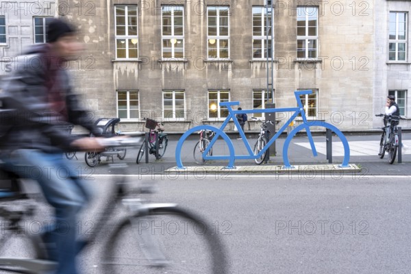 Bicycle parking spaces, with so-called leaning bars and a large blue bicycle silhouette, to make parking spaces visible at Bochum City Hall, North Rhine-Westphalia, Germany
