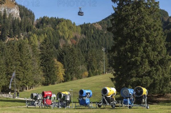 Snow cannons in a meadow surrounded by mountains and autumn forests, Tegelbergbahn cabin in the air, Schwangau near Füssen, Ostallgäu, Allgäu, Bavaria, Germany
