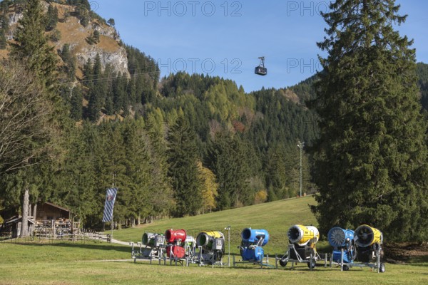 Snow cannons in front of a forest, mountains in the background, Tegelbergbahn cabin floating, Reith-Alpe, Schwangau near Füssen, Ostallgäu, Allgäu, Bavaria, Germany
