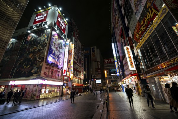 Street with illuminated shops and neon signs at night in Akihabara, Electric City, Tokyo, Japan