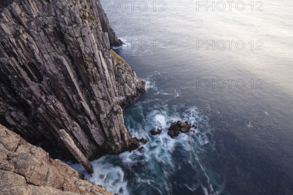 Totem Pole at The Lanterns. Long exposure at sunrise shows glowing dawn over the dramatic cliffs of Cape Hauy. Waves hit the steep cliffs. Cape Hauy, Tasman Peninsula, Tasmania, Australia