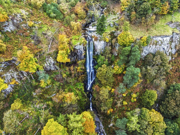 Autumn colours over Pistyll Rhaeadr Waterfall and Berwyn Mountains from a drone, Oswestry, Shrewsbury, Wales, England, United Kingdom