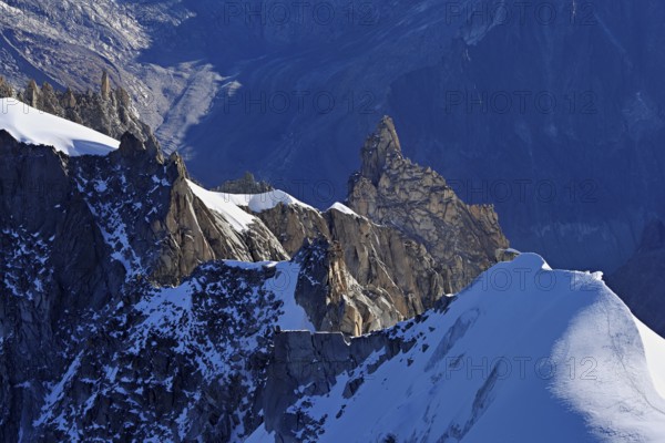 Rugged rocks jut out of a snow-covered mountain, viewing platform, Aiguille du Midi mountain station, Chamonix-Mont-Blanc, Haute-Savoie, France