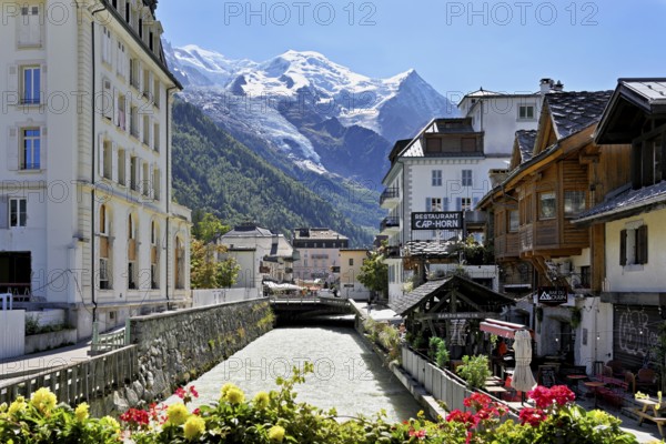 Glacier river Arve flows through the city, with the snow-capped Mont-Blanc mountain range behind, Chamonix-Mont-Blanc, Haute-Savoie, France