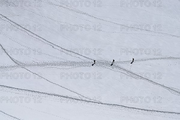 A group of mountaineers runs across a snow-covered mountain, Aiguille du Midi, Chamonix-Mont-Blanc, Haute-Savoie, France
