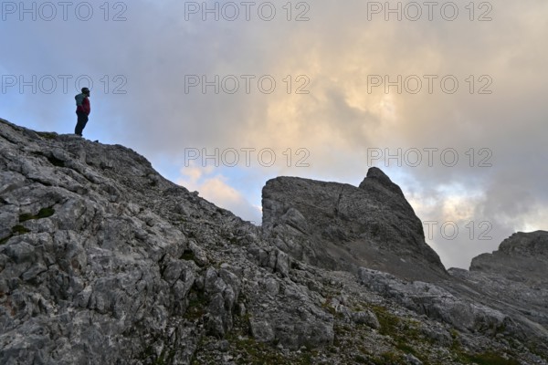 Mountaineer enjoys solitude in the Steinernes Meer with a view of the summit of Wildalmkirchl, Berchtesgaden Alps, Austria