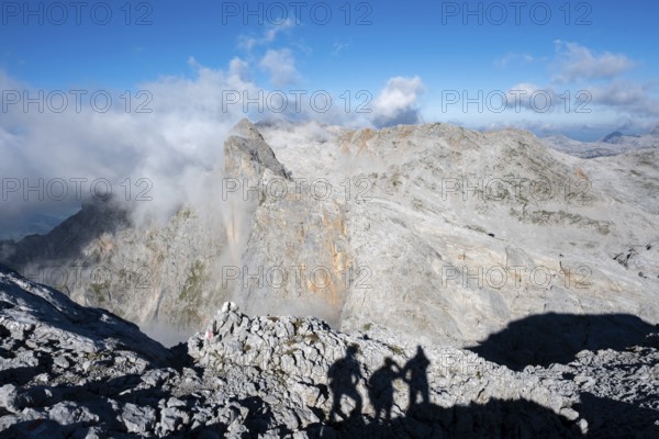 Shade of 3 mountaineers and view over the Steinerne Meer with Wildalmkirchl and Selbhorn, Berchtesgaden Alps, Austria