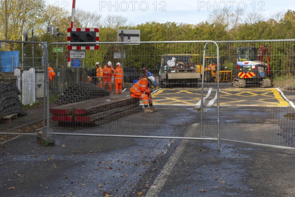 Road and rail level crossing closed, Network Rail railway line upgrade maintenance, Melton, Suffolk, England, UK autumn 2025