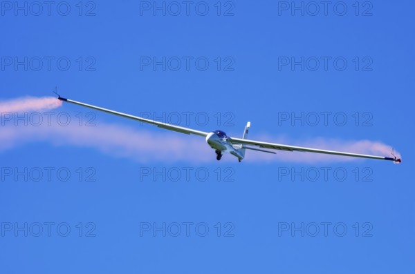 An SZD-59-1 ACRO glider, registration D-1138, during a demonstration as part of an air show at the Fliegerbergfest of the Rossfeld Luftsportverein in Metzingen-Glems, Baden-Württemberg, Germany, for editorial use only
