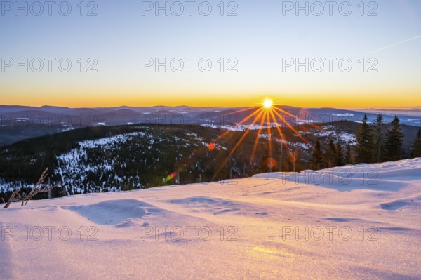 Sunrise over the hills of czech republic from Mount Lusen wth the view over the hills of the bavarian forest in winter, Bavaria, Germany