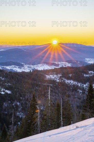Sunrise over the hills of czech republic from Mount Lusen wth the view over the hills of the bavarian forest in winter, Bavaria, Germany