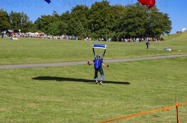 Landing of skydivers during an aerial acrobatic performance as part of an air show at the Rossfeld Air Sports Association Air Sports Festival on Rossfeld in Metzingen-Glems, Baden-Württemberg, Germany, for editorial use only