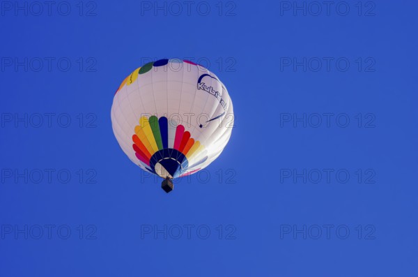 A hot air balloon, registration D-OÖJ, rises into the air as part of an air show at the Fliegerbergfest of the Rossfeld Luftsportverein in Metzingen-Glems, Baden-Württemberg, Germany, for editorial use only
