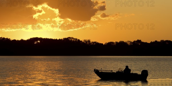 A boat on Lake Gudelack at sunset, Lindow (Mark), Stechlin-Ruppiner Land nature park Park, Brandenburg, Germany